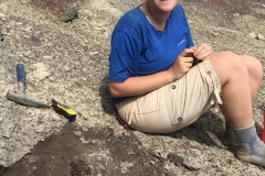 NCSU undergraduate student Liv Swayze helps uncover the leg bone of a new species of feathered dinosaur in New Mexico.