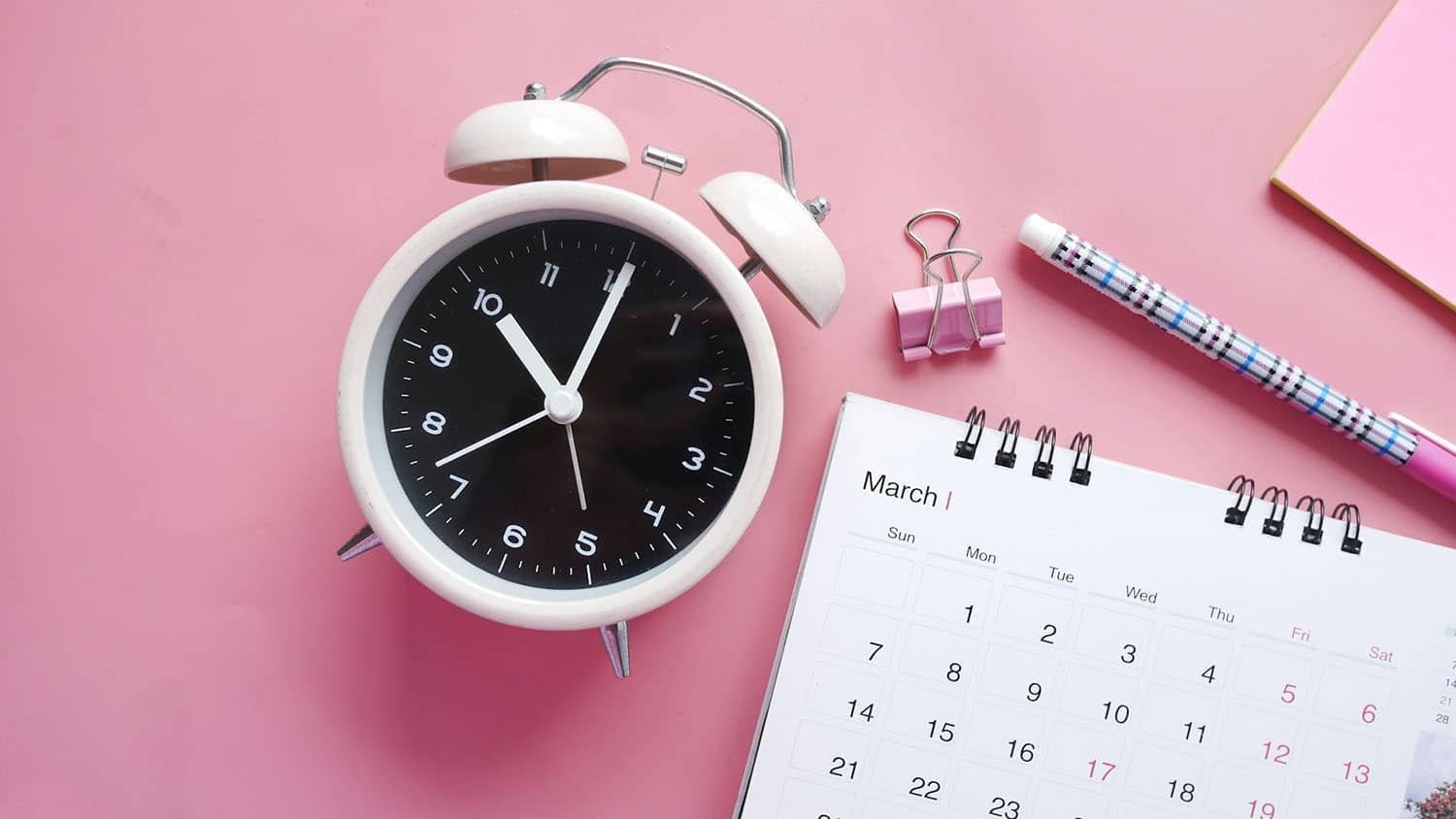 photo shows an alarm clock next to a calendar